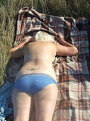 Horny mother outdoors sunning herself. vagina tattoo and piercings, what a whore!