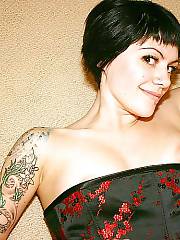 Hot tattooed black haired girl showing her cute breasts and pierced pussy.