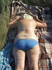 Horny mother outdoors sunning herself. vagina tattoo and piercings, what a whore!