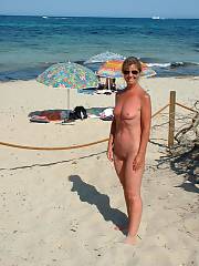Hard body grandma out on vacation, getting naked on the warm beach and giving a hand job