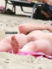 Nice skinny mom woman was caught liking sun baths nude on the public beach and her nice bald cunt was photographed closeup by voyeurists