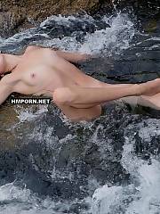 Nudist girl posing naked  showing her fuckable body in the water of ocean near the desert beach